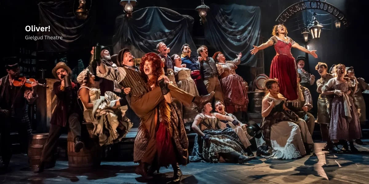 Cast of Oliver the musical London production on stage singing